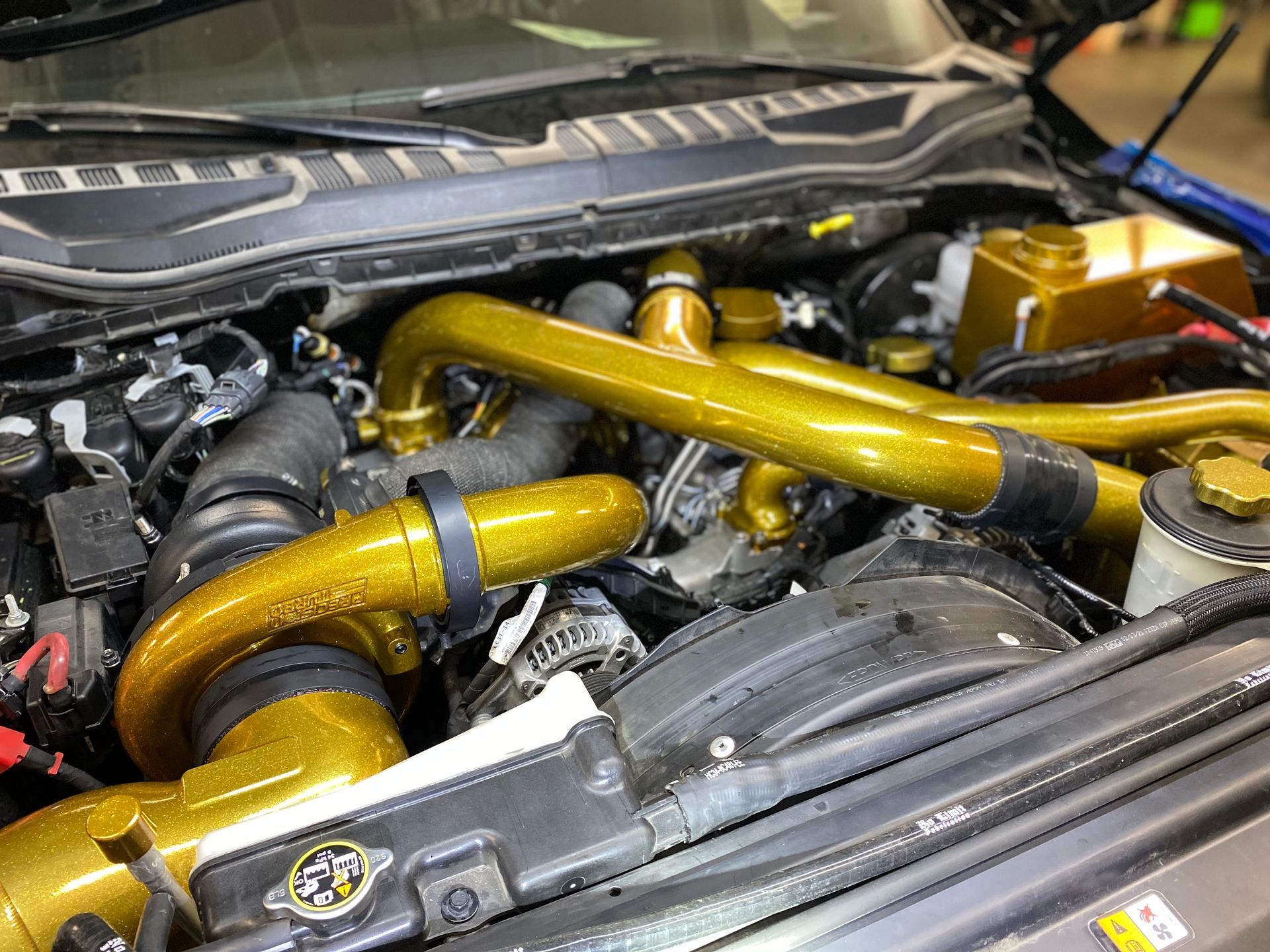 A close up of a car engine with the hood open.