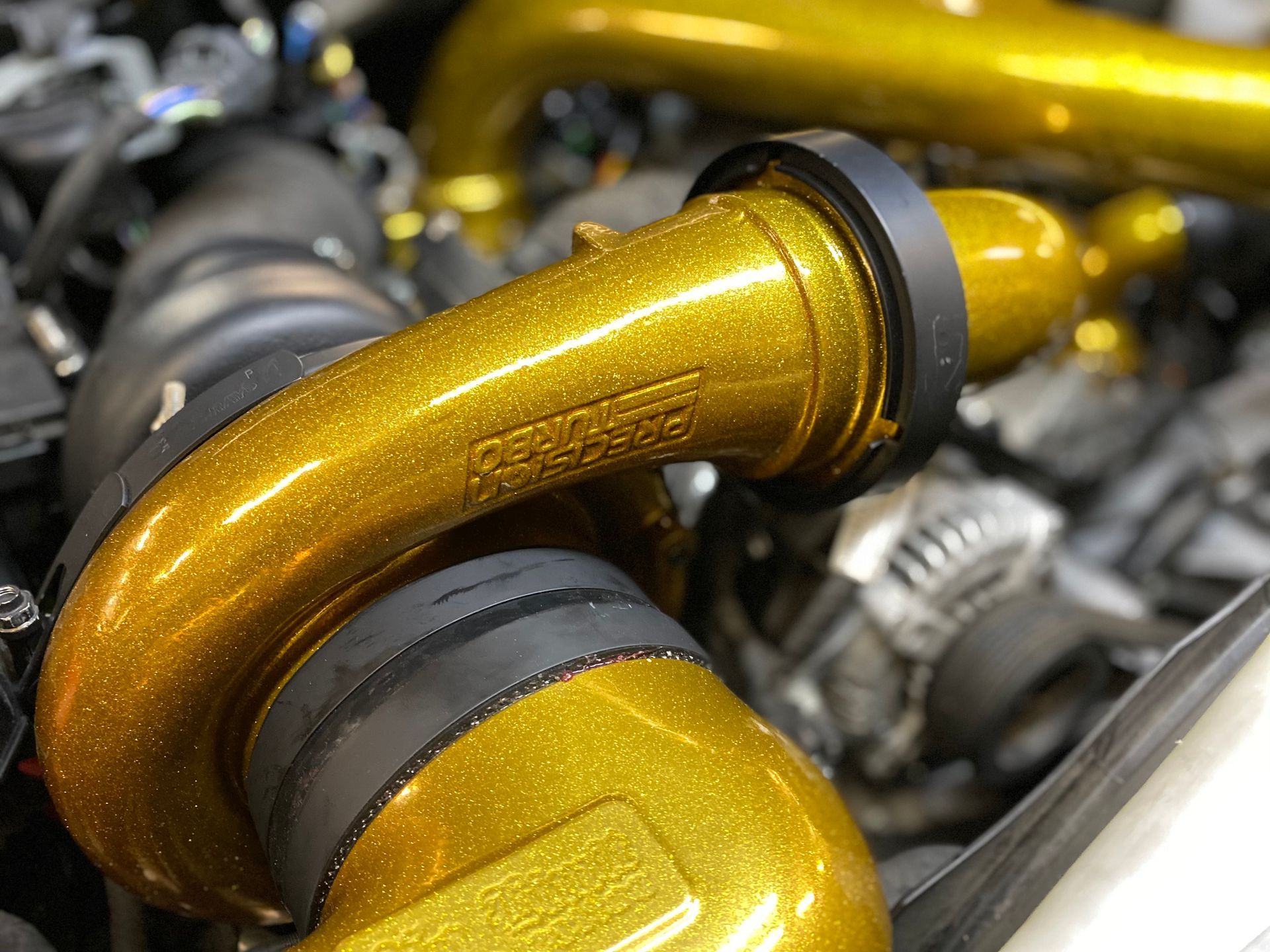A close up of a gold pipe on a car engine