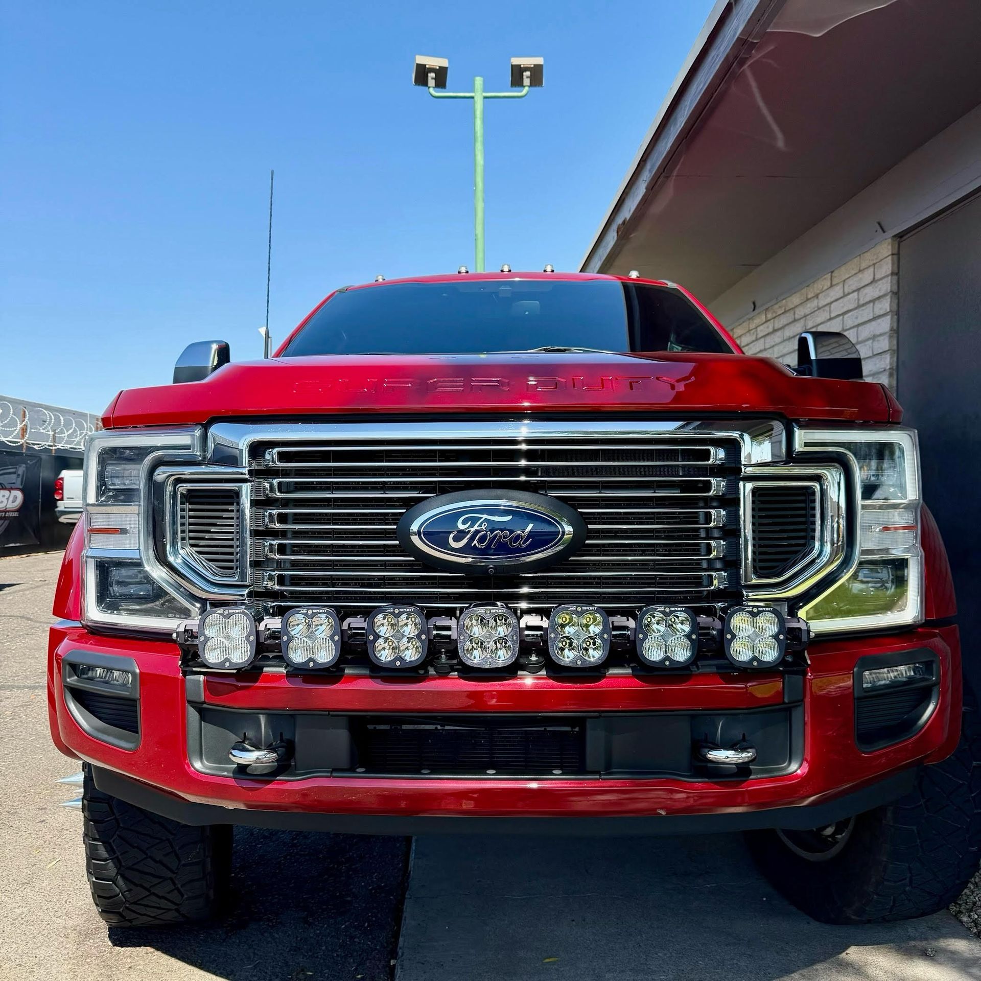 A red ford truck is parked in front of a building