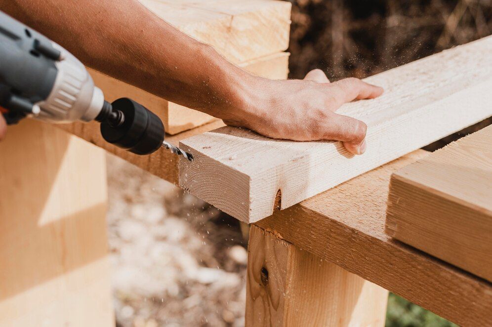 A person is using a drill to drill a hole in a piece of wood.