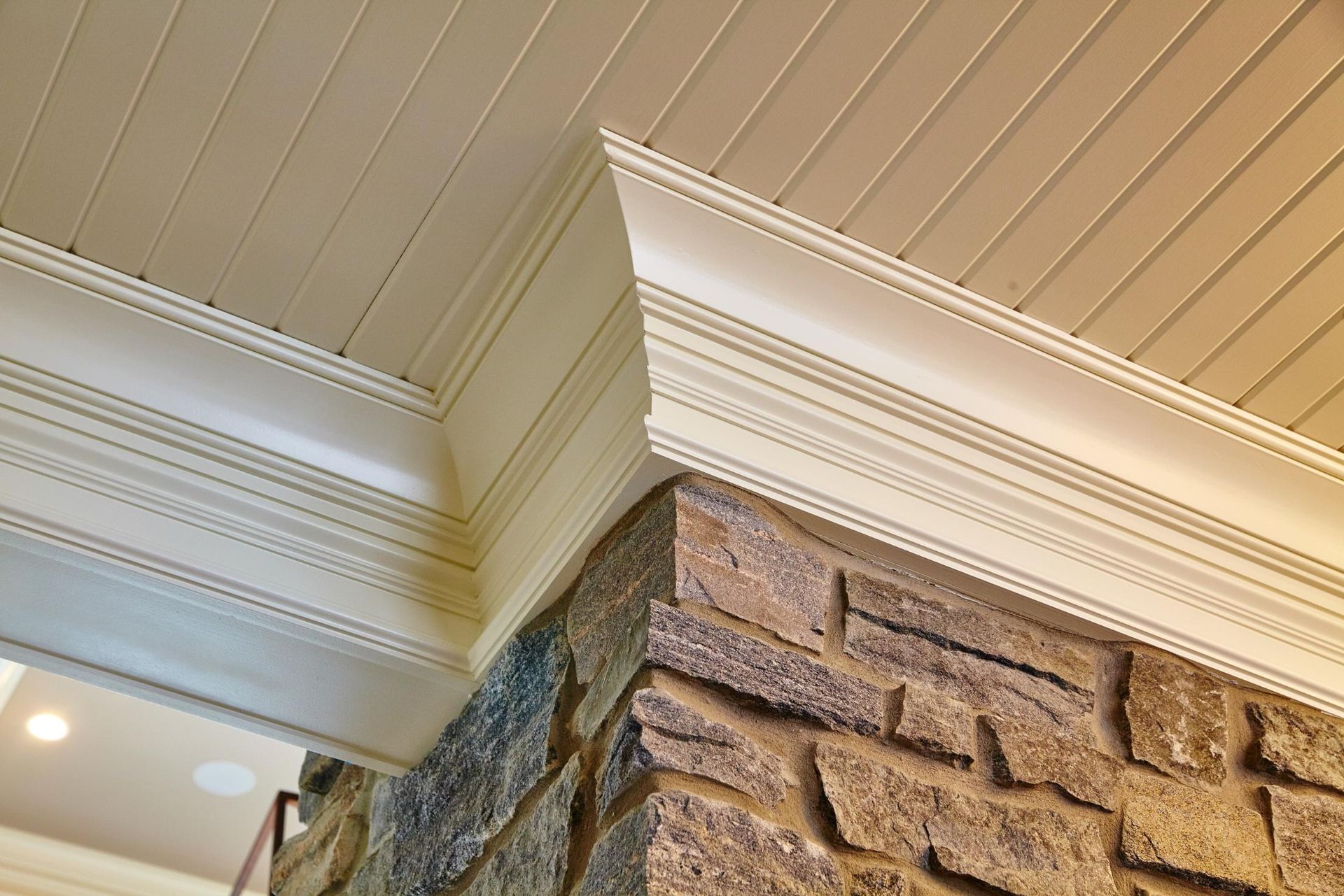 A brick fireplace with a white trim on the ceiling.