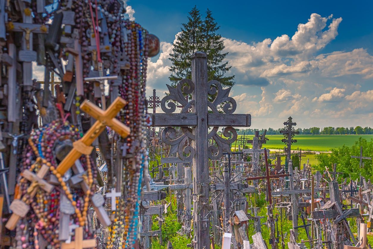 A cemetery filled with lots of crosses and rosary beads.