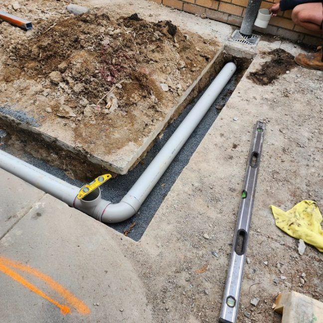 A Drain Pipe Is Being Installed In A Hole In The Ground — RAW Plumbing & Gasfitting In Pearce, ACT