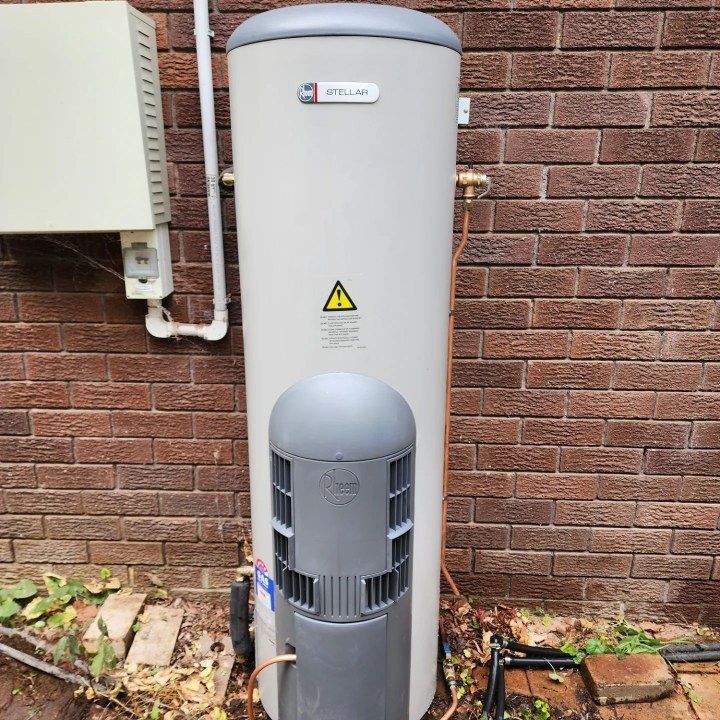 A Water Heater Is Sitting Outside Of A Brick Building — RAW Plumbing & Gasfitting In Pearce, ACT