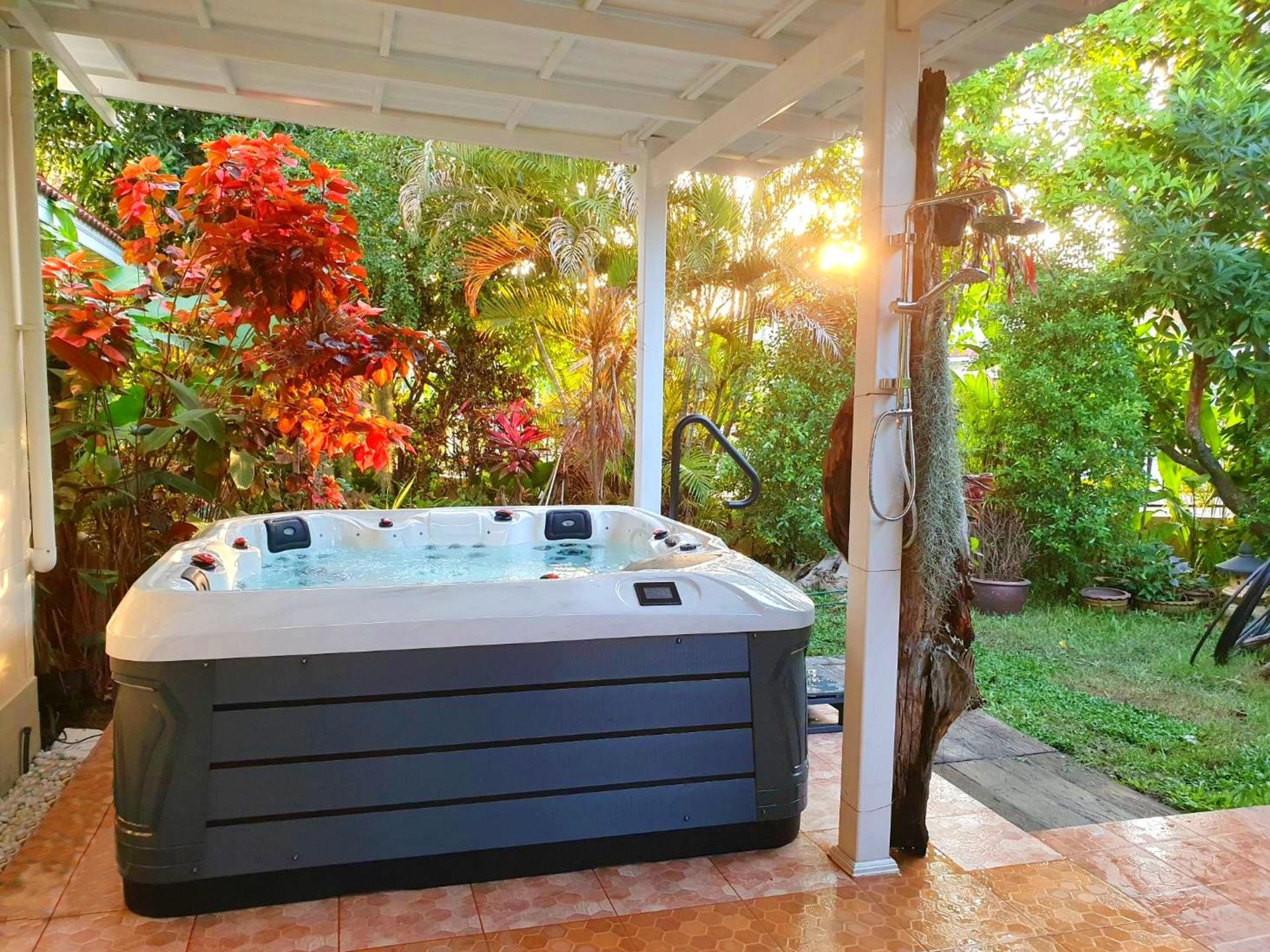 Q&G outdoor hot tub placed in a lush green front-yard garden in San Kamphaeng, Chiang Mai