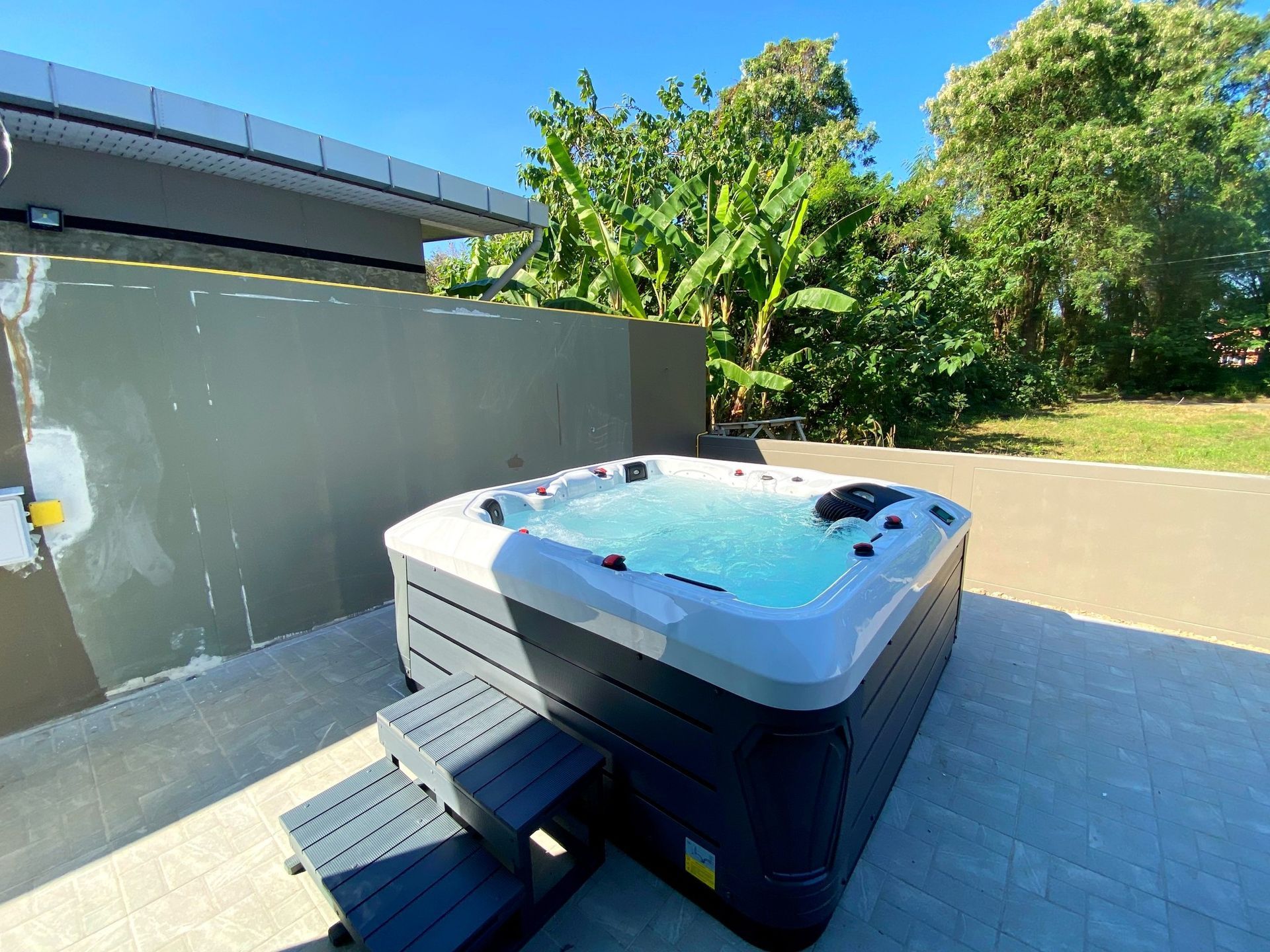 Q&G outdoor hot tub on a side-of-house patio in Mueang Kanchanaburi District