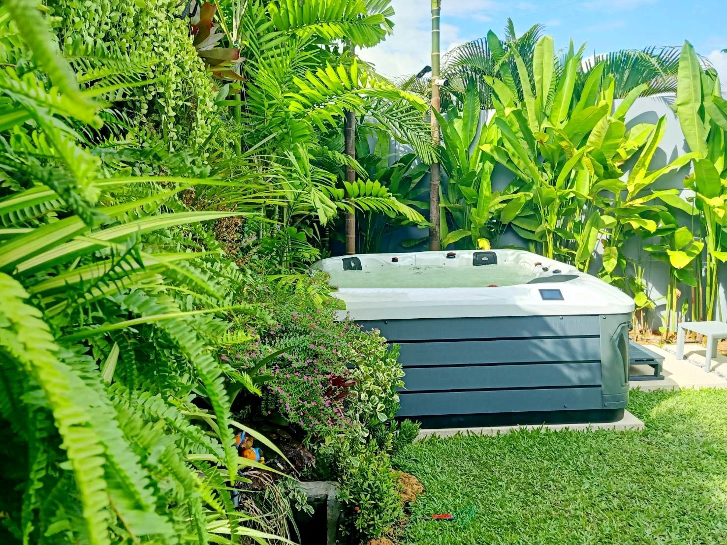Q&G outdoor hot tub nestled in a tropical garden corner with plants in Thalang District, Phuket