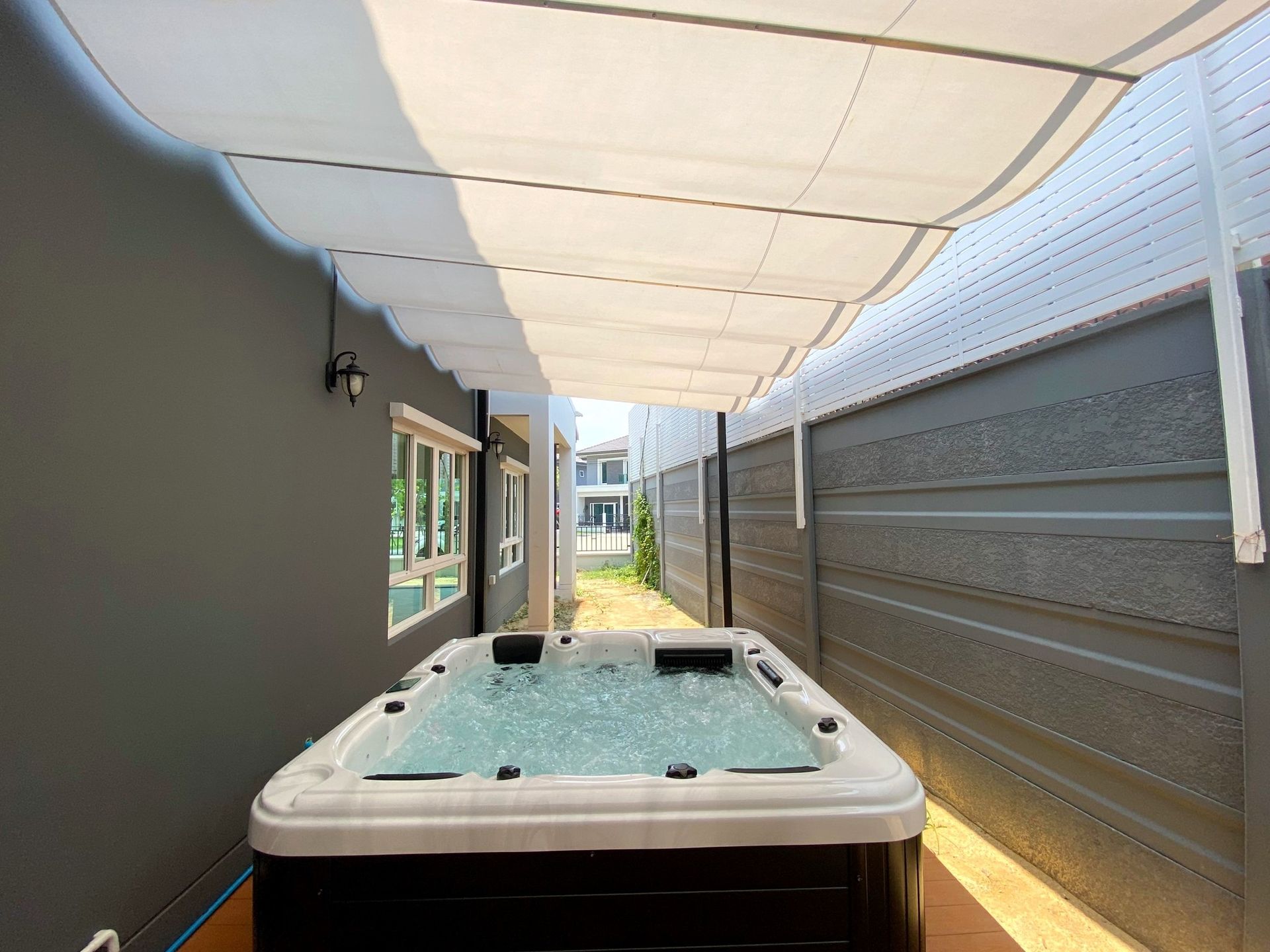 Q&G outdoor hot tub under a roofed structure in a covered side yard in Chom Thong District, Bangkok