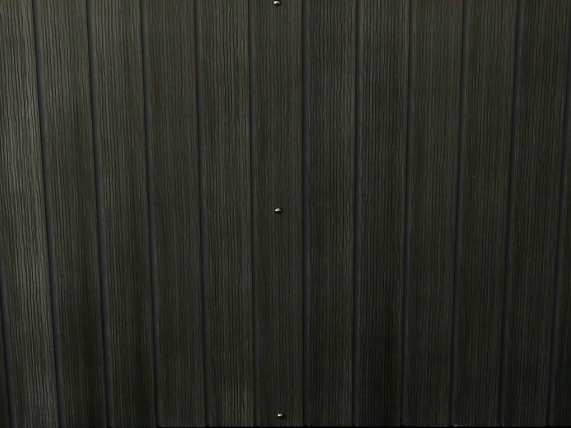 Close-up view of the exterior cabinet panel of an above-ground swim spa, featuring a wood-texture finish designed for durability, weather resistance, and a modern outdoor appearance.