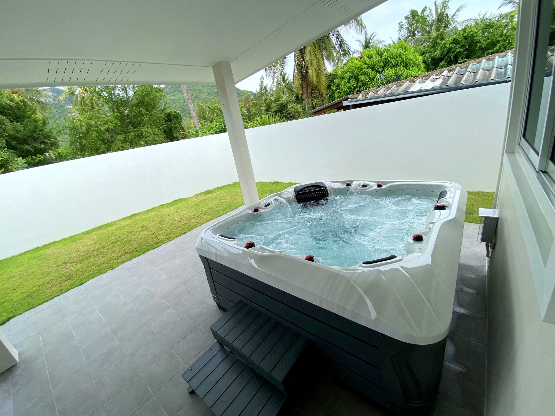 Q&G outdoor hot tub on a covered back patio in Sam Roi Yot, offering shaded relaxation