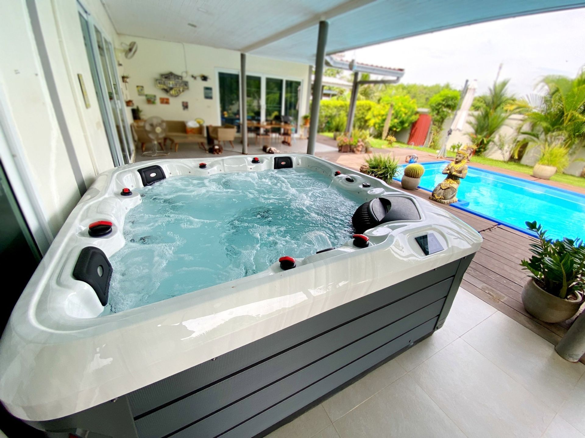 Q&G outdoor hot tub on a covered patio beside a swimming pool in Phanom Dong Rak, Surin
