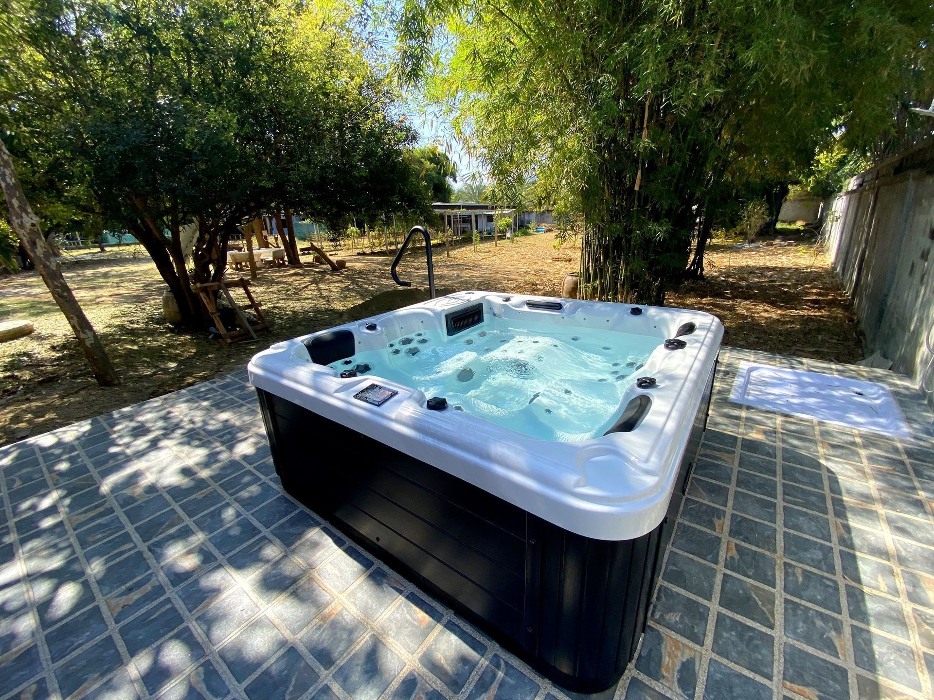 Q&G outdoor hot tub tucked into a backyard bamboo corner in Amphoe Mueang, Kanchanaburi