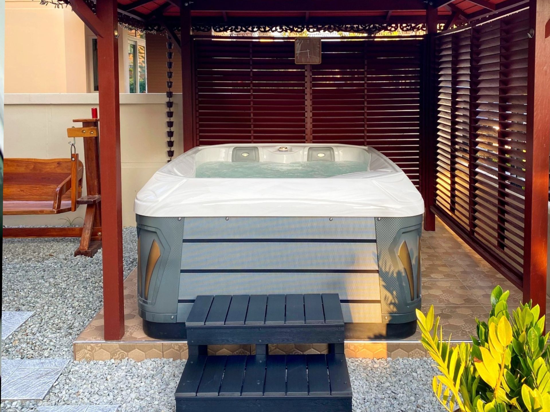 Q&G outdoor hot tub inside a small pavilion in the front yard of a home in Si Racha District, Chon Buri