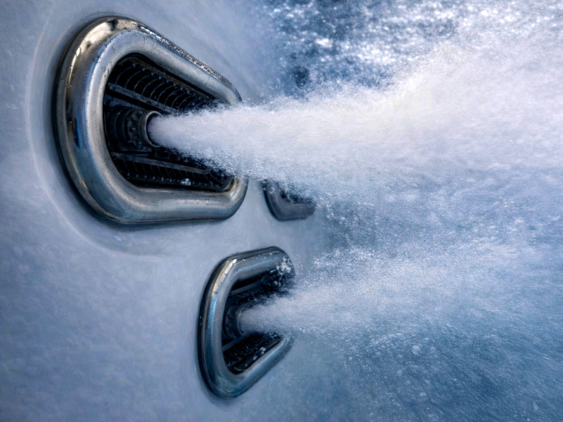 Close-up view of powerful counter current swim jets releasing high-pressure water flow underwater, designed for continuous swimming and resistance training in a swim spa.