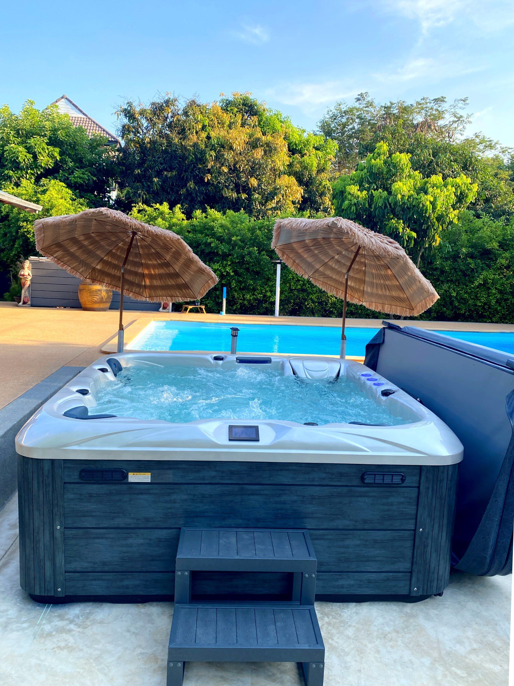Outdoor hot tub by a swimming pool in Thailand from QandGTub, illustrating tips for choosing a durable outdoor hot tub with long-term value