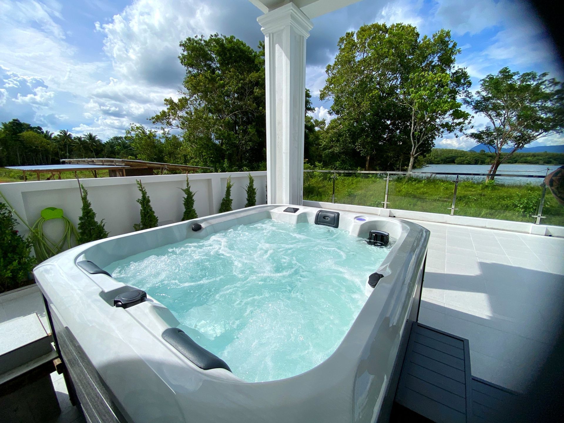 Q&G OCEANFRONT Alfa hot tub on a spacious covered back terrace with views of a lake and surrounding mountains in Thung Song District
