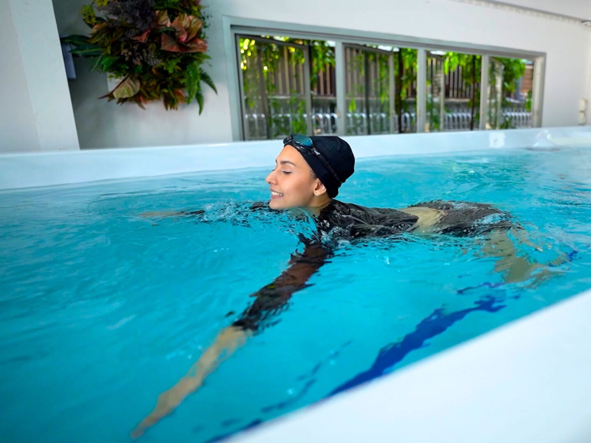 ผู้หญิงกำลังว่ายน้ำฟรีสไตล์ใน Swim Spa Ultimate 16 เพื่อออกกำลังกาย