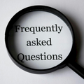 Magnifying glass over the words “Frequently asked Questions” on a white background