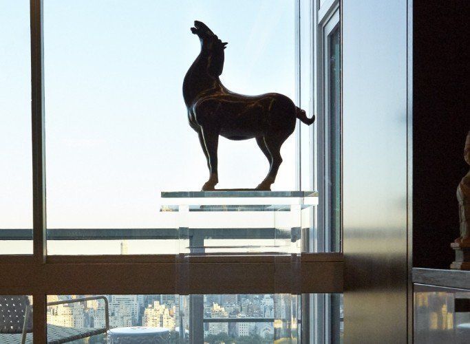 A statue of a horse is in front of a window