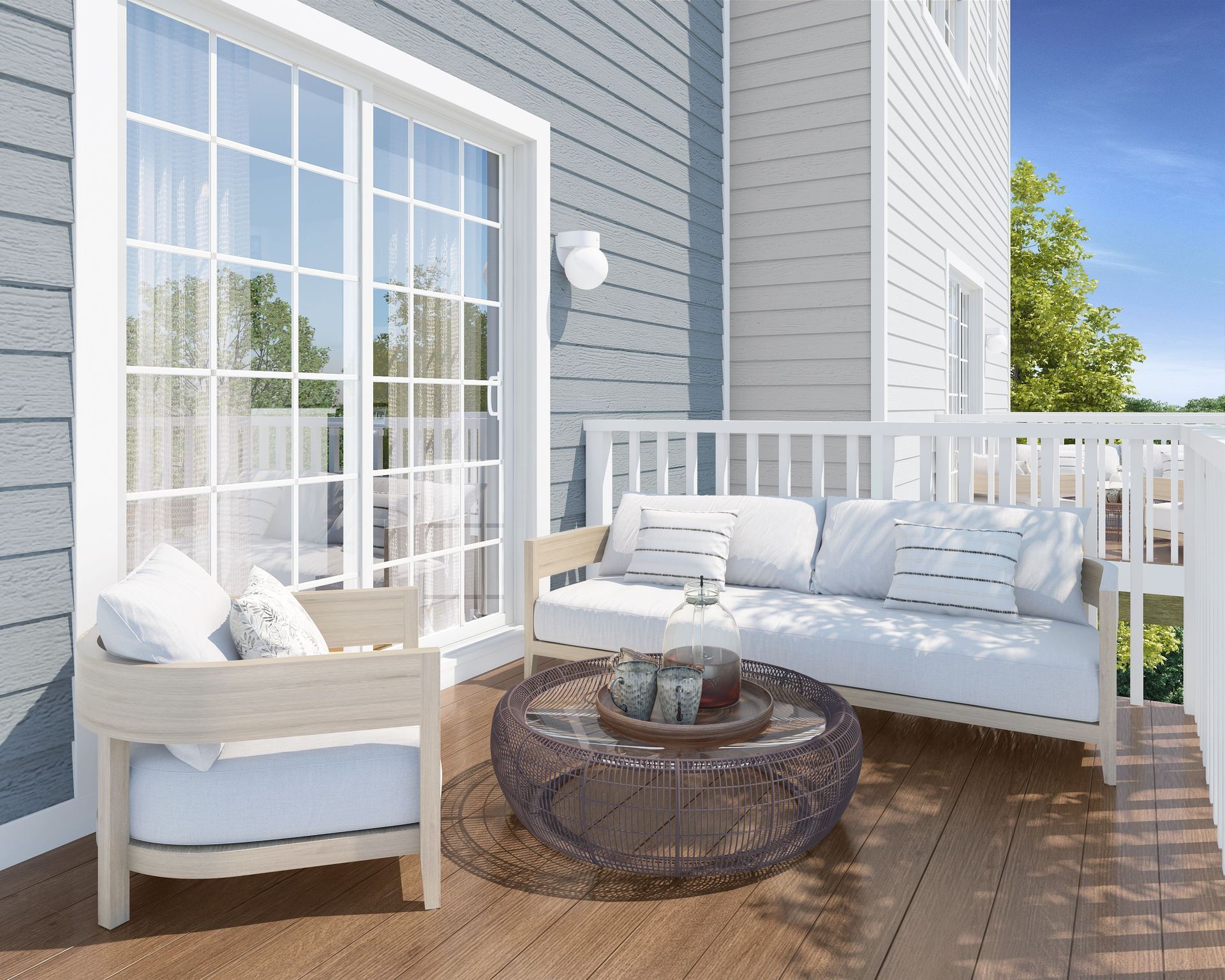 Bright outdoor patio with white sofa, chair, and round table beside sliding glass doors.