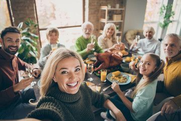 Group of friends gathered around a dining table, smiling and sharing a meal in a cozy home dining room.
