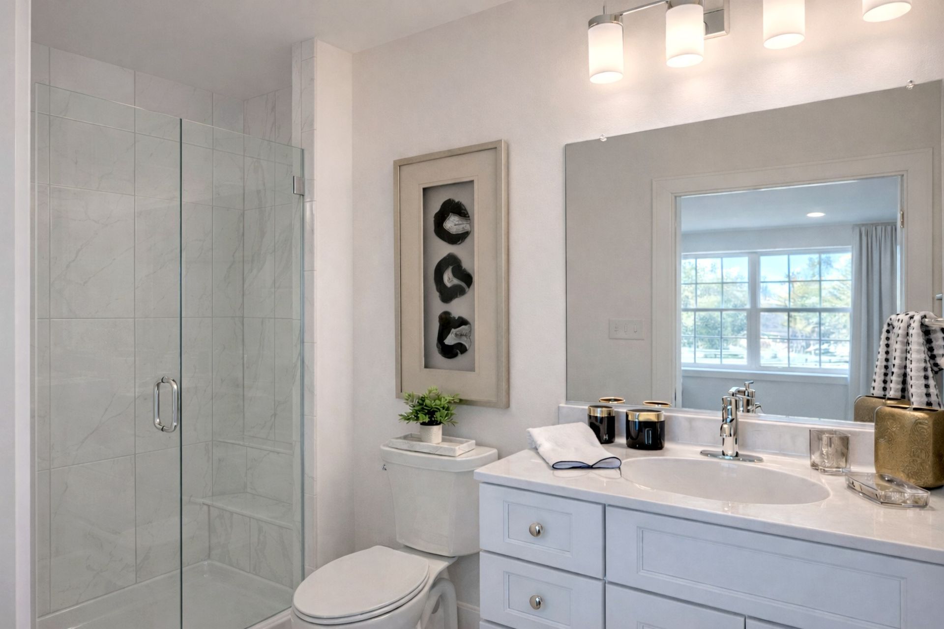 Bright bathroom with glass shower, white vanity, mirror, and window light