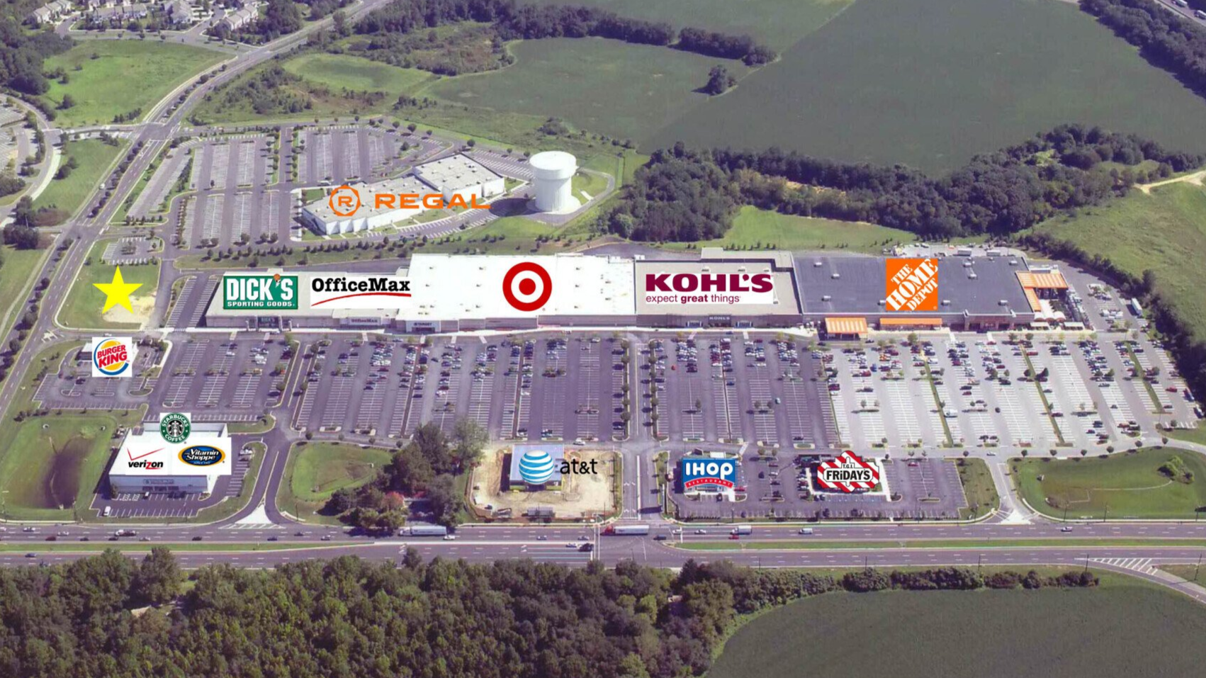 Aerial view of a Target, IKEA, and other stores with parking lots and surrounding green fields