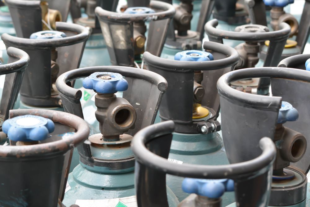 Rows of Gas Cylinders With Blue Valves Clustered — Kuranda Gas & Supplies In Daintree, QLD