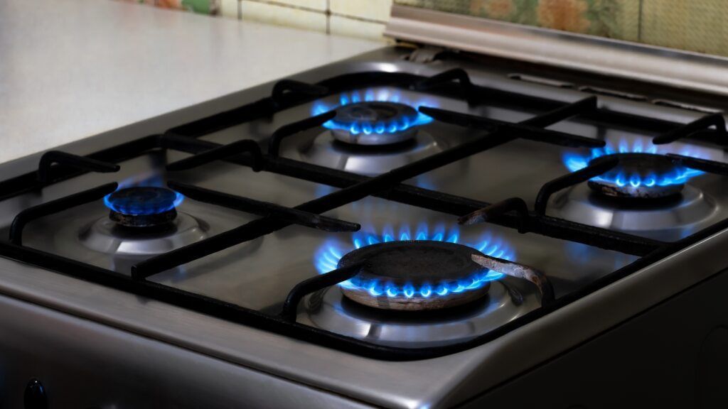 Gas Stove with Four Blue Flames Burning — Kuranda Gas & Supplies In Koah, QLD