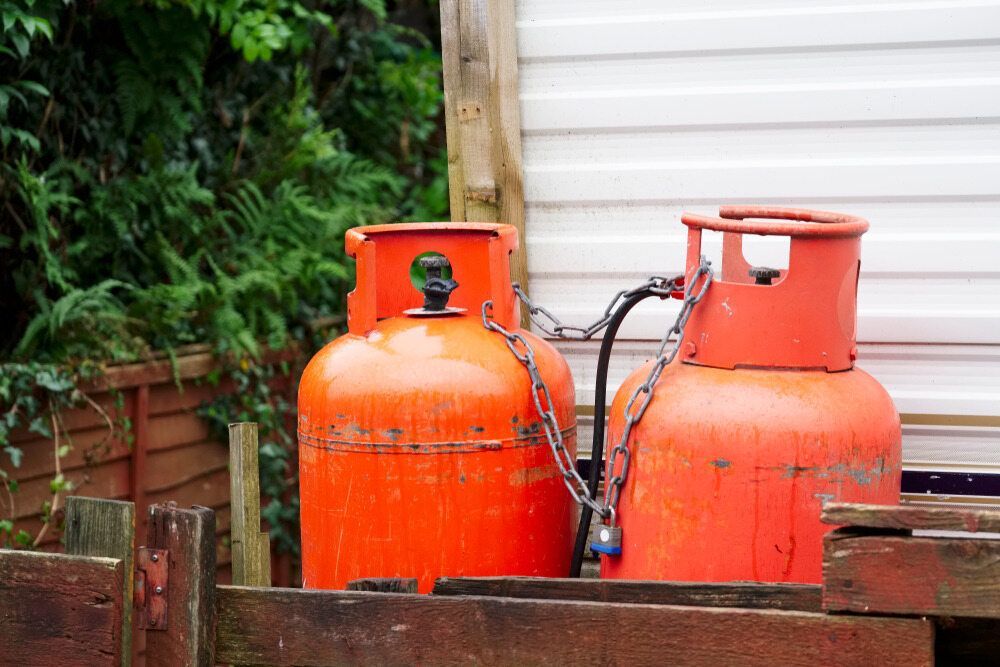 Two Orange Propane Tanks Chained Together Outdoors — Kuranda Gas & Supplies In Smithfield, QLD