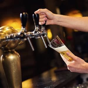 Person Pouring Beer from A Tap Into a Glass at A Bar — Kuranda Gas & Supplies In Koah, QLD