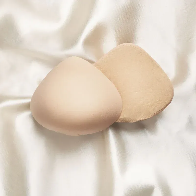 a pair of breast pads sitting on top of a white cloth .