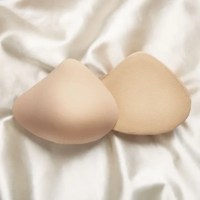 a pair of breast pads sitting on top of a white cloth .