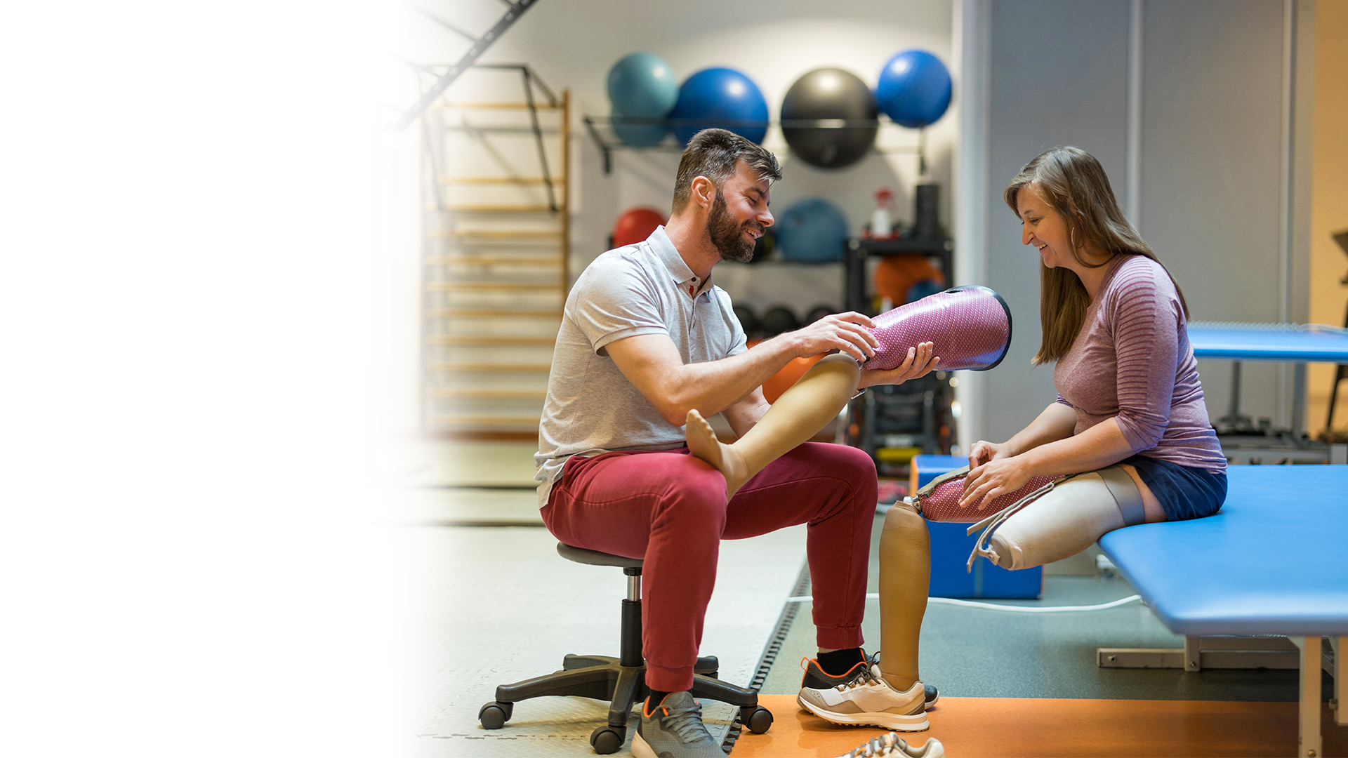 A man is helping a woman with a prosthetic leg.
