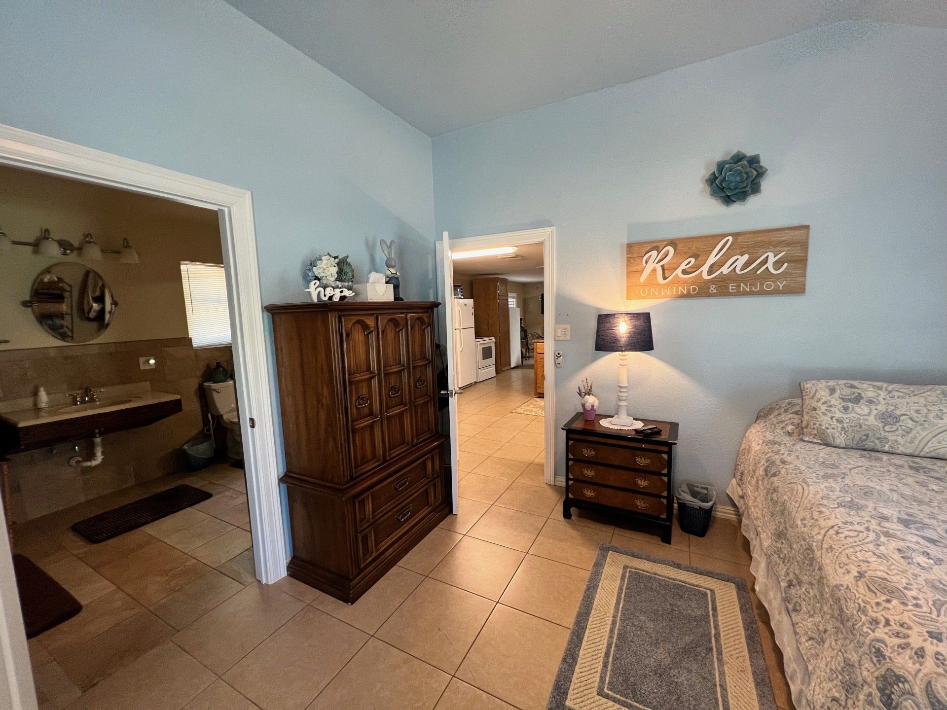 a bedroom with a sign on the wall that says `` relax '' .
