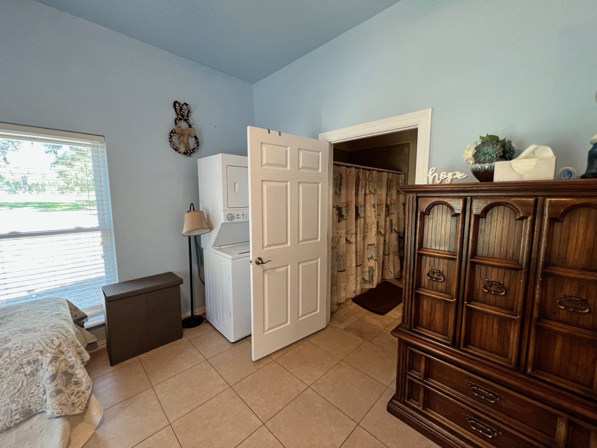 a bedroom with a washer and dryer and a dresser .