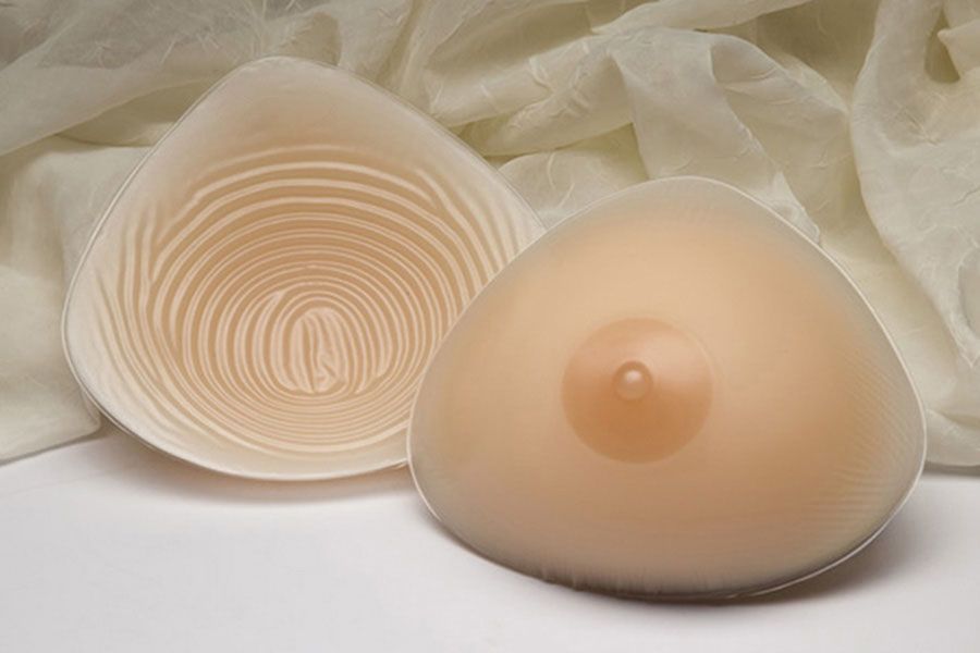 a pair of breast prosthetics sitting on top of a white cloth .