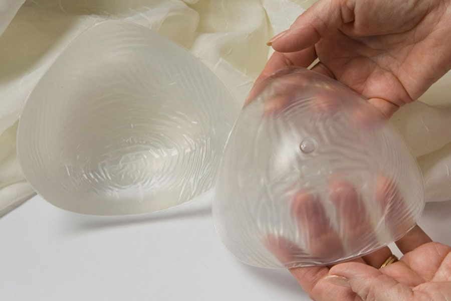 a person is holding a clear plastic object in their hand .