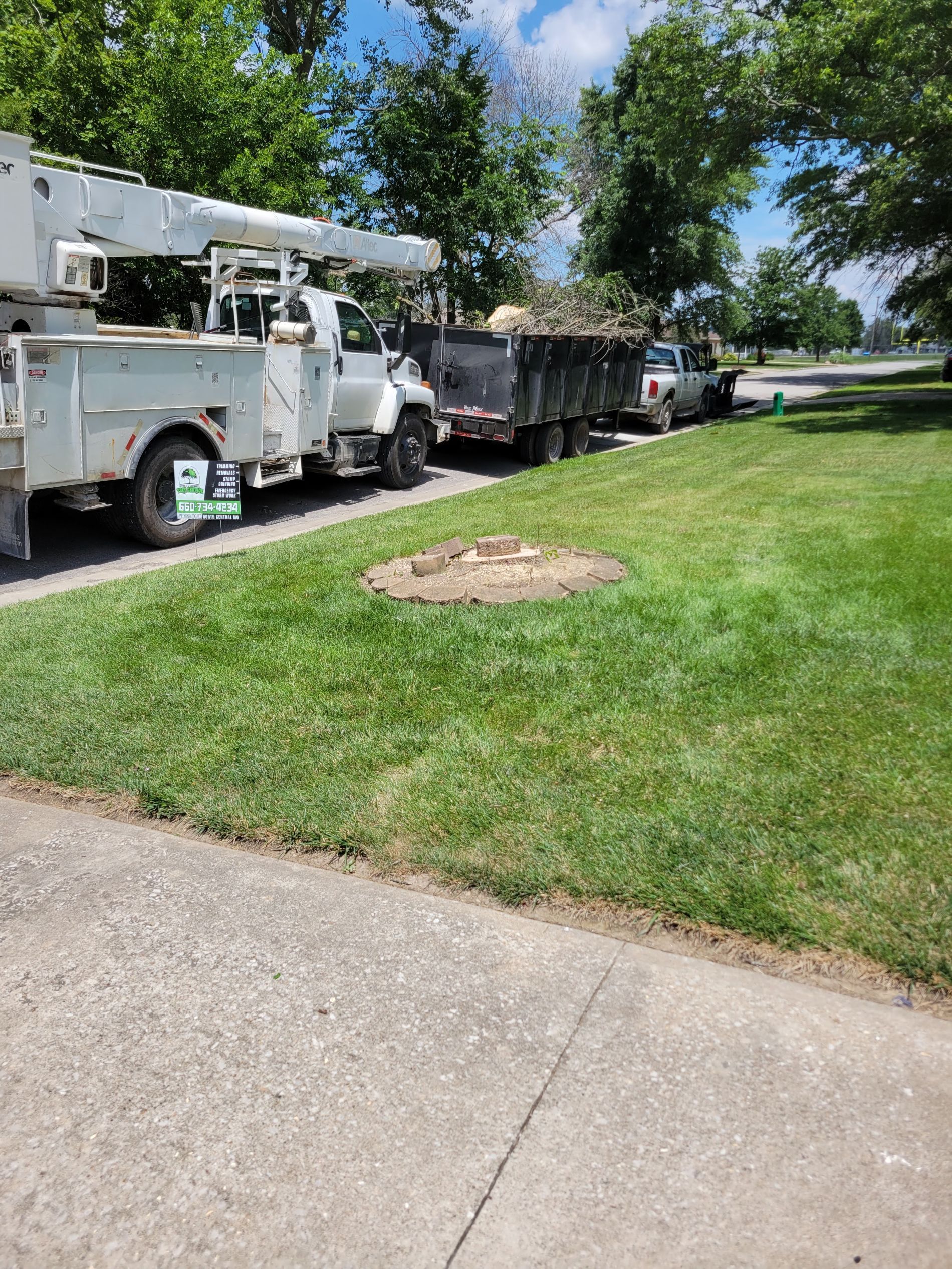 Utility truck parked beside a lawn and sidewalk on a sunny day