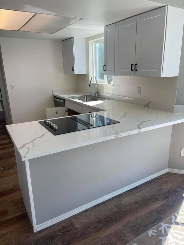 A kitchen with white cabinets and a stove top oven.