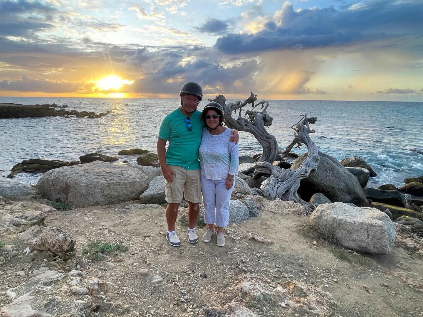Couple by Aruba’s rocky coast at sunset