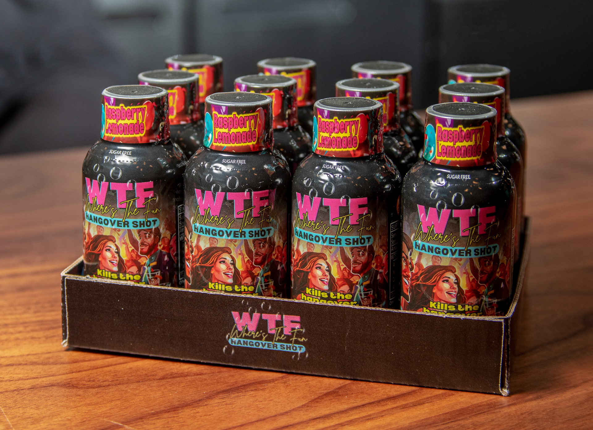 A display box holding twelve dark bottles of