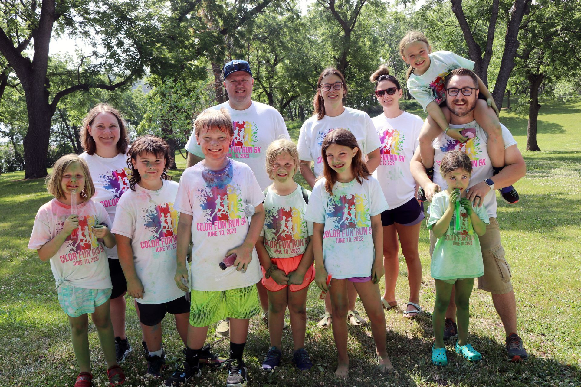 A group of people are posing for a picture in a park.