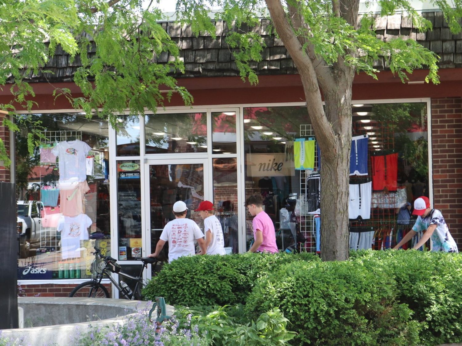 A group of people are standing outside of a store.