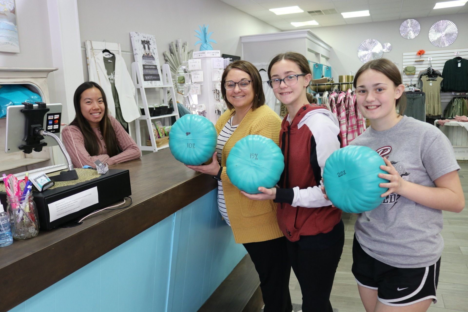 A group of women are standing in a store holding bowling balls.