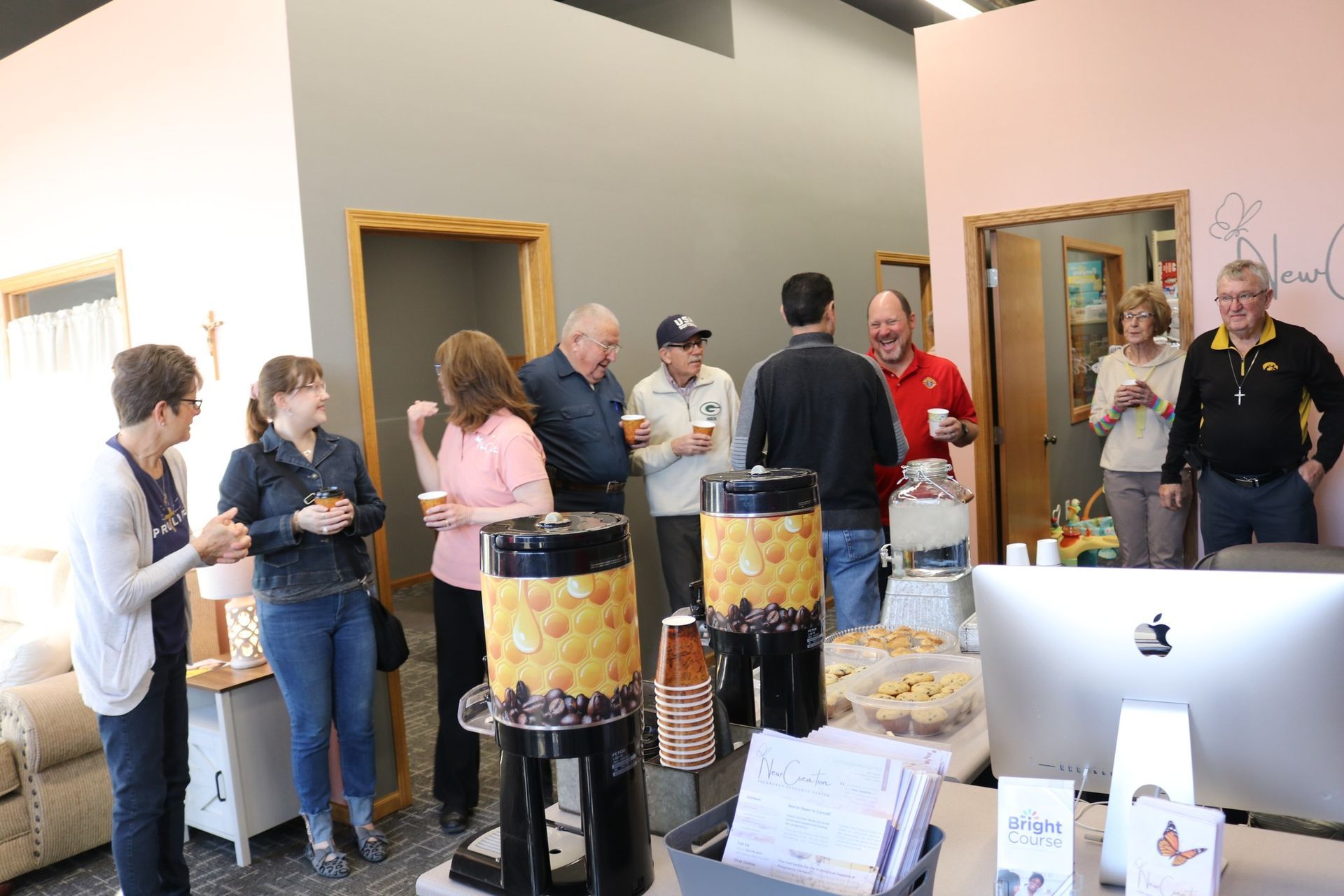 A group of people are standing around a table in a room.