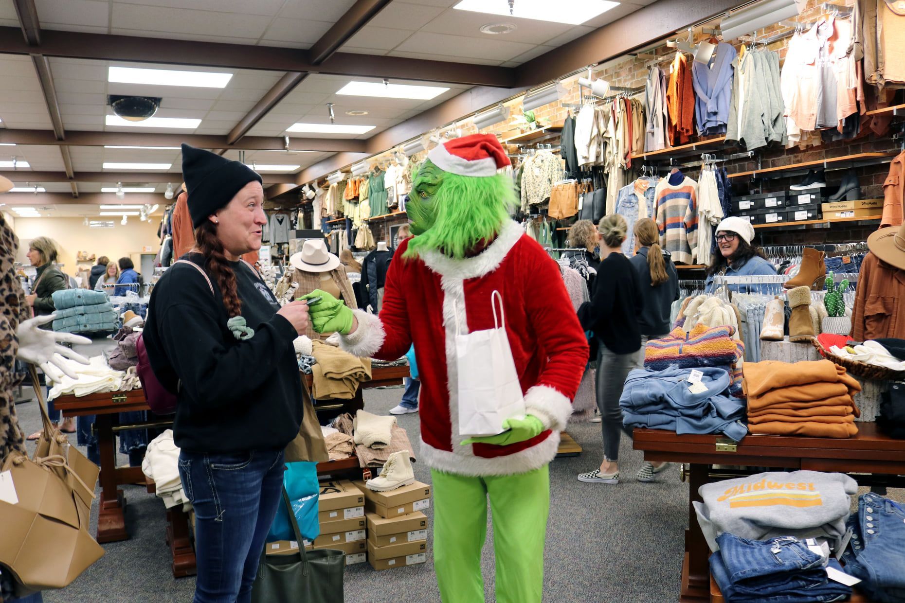 A woman is talking to a grinch in a store.