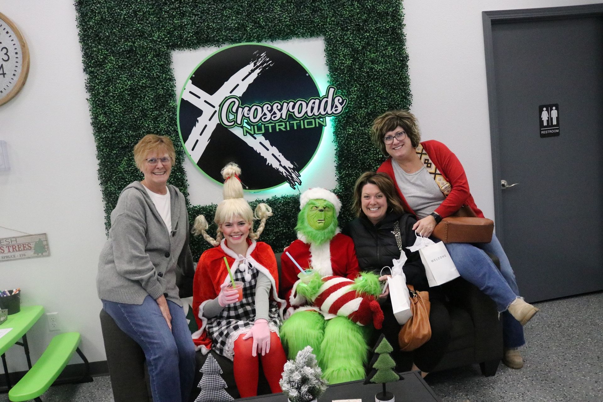 A group of women are posing for a picture with the grinch.