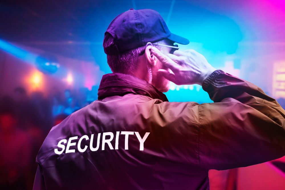 Male security officer attentively listens through earphones while on duty in a nightclub — Alarm Monitoring in Mittagong, NSW