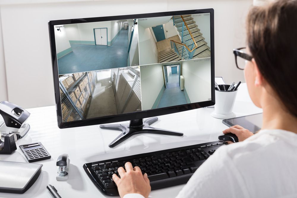Professional businesswoman monitoring CCTV footage on a computer in her office for security purpose — Alarm Monitoring in Bowral, NSW